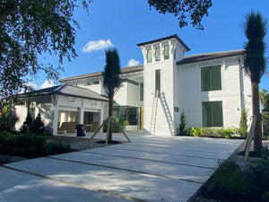 The image is of a seamless aluminum gutter installation on a modern residential home. 